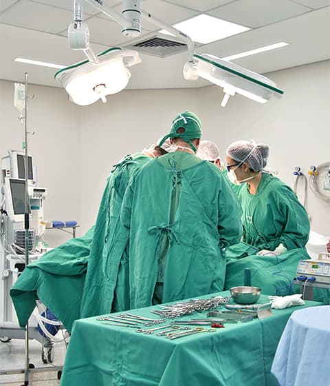 Equipe cirúrgica realizando procedimento em centro cirúrgico