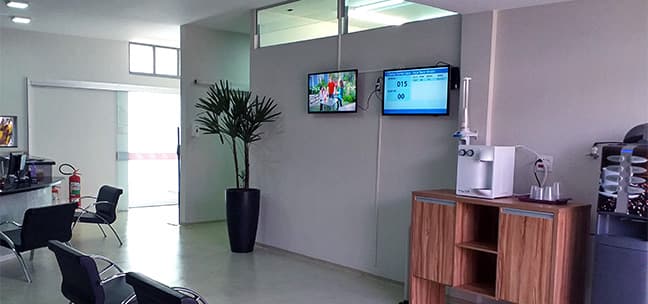 Recepção interna da Santa Casa com painéis de senha eletrônica