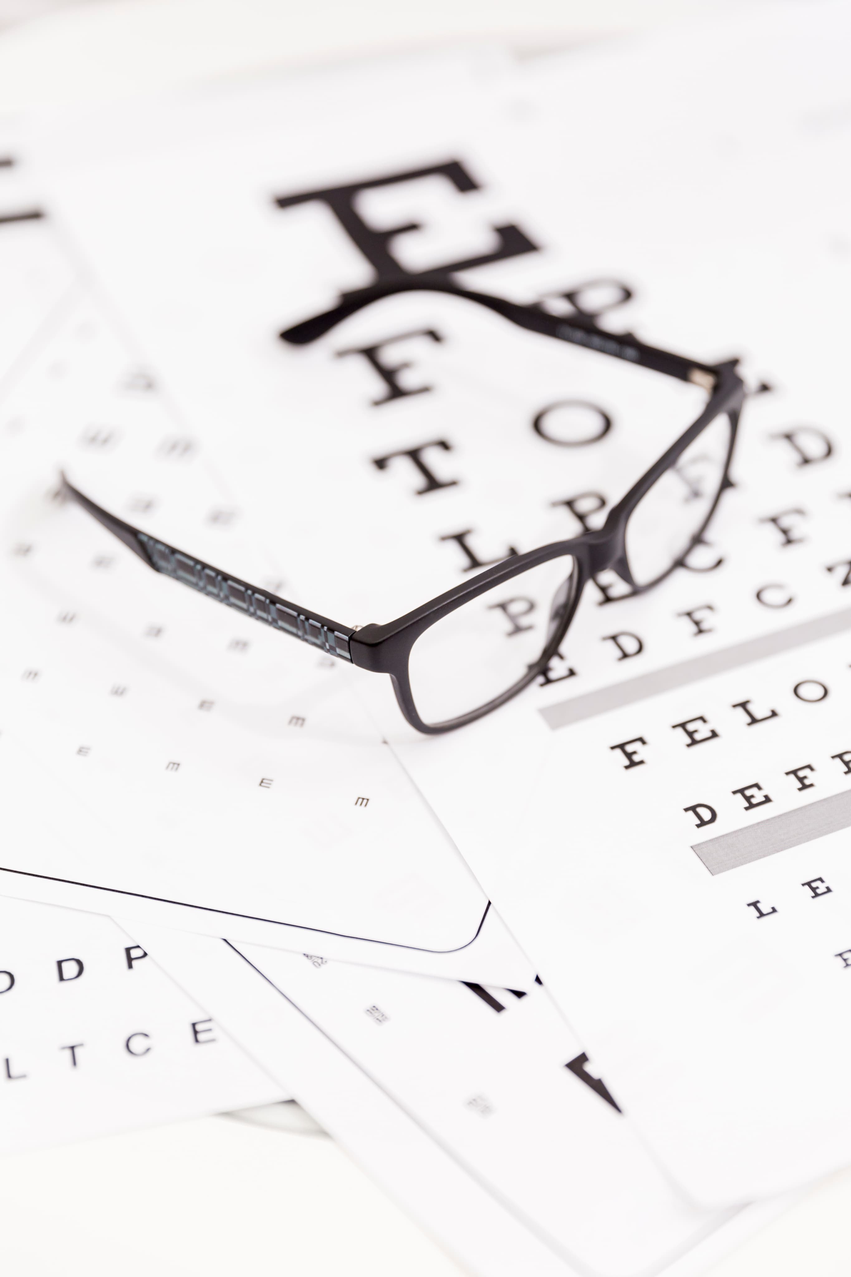 Óculos sobre tabela de teste de acuidade visual