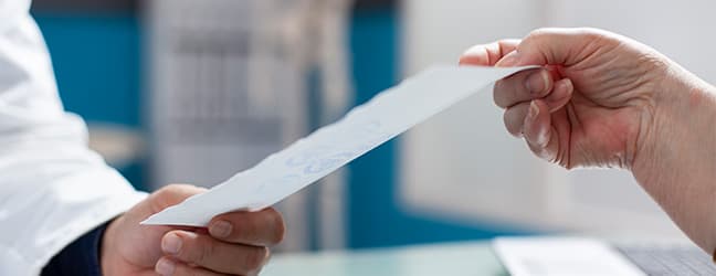 Profissional de saúde entregando um documento, representando o cadastro de doação automática da Nota Fiscal Paulista